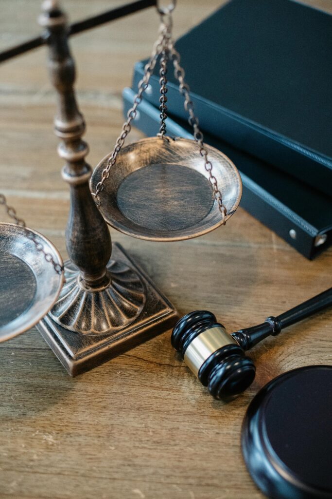 pexels-photo-5668882-5668882 From above of judicial symbols consisting of Scales of Justice and small judge hammer with curly handle